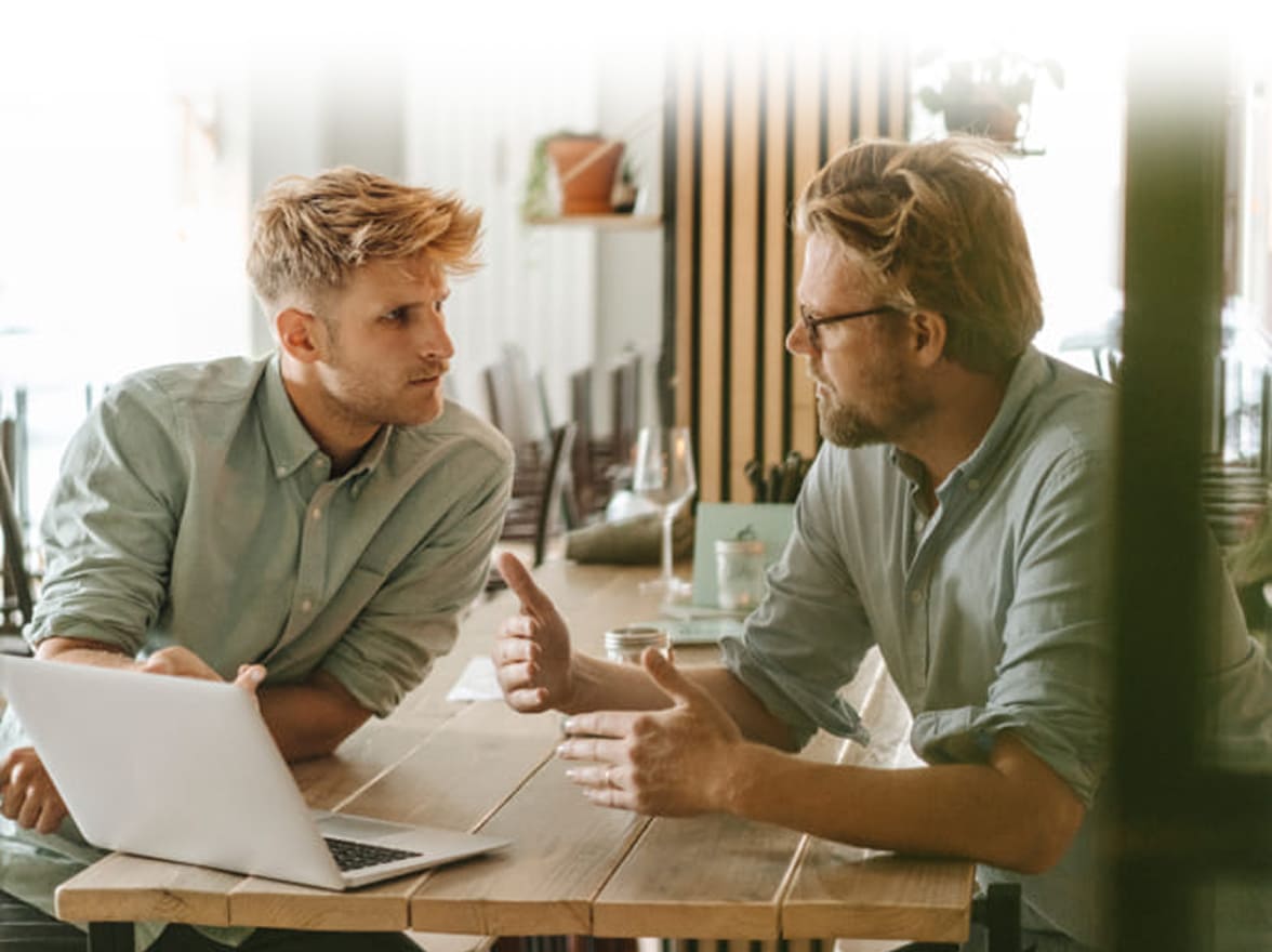 due uomini seduti al tavolo davanti ad un computer