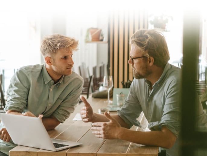 due uomini seduti al tavolo davanti ad un computer