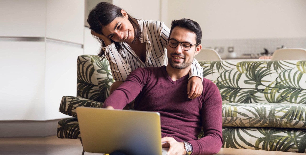 Couple in living room looking at laptop