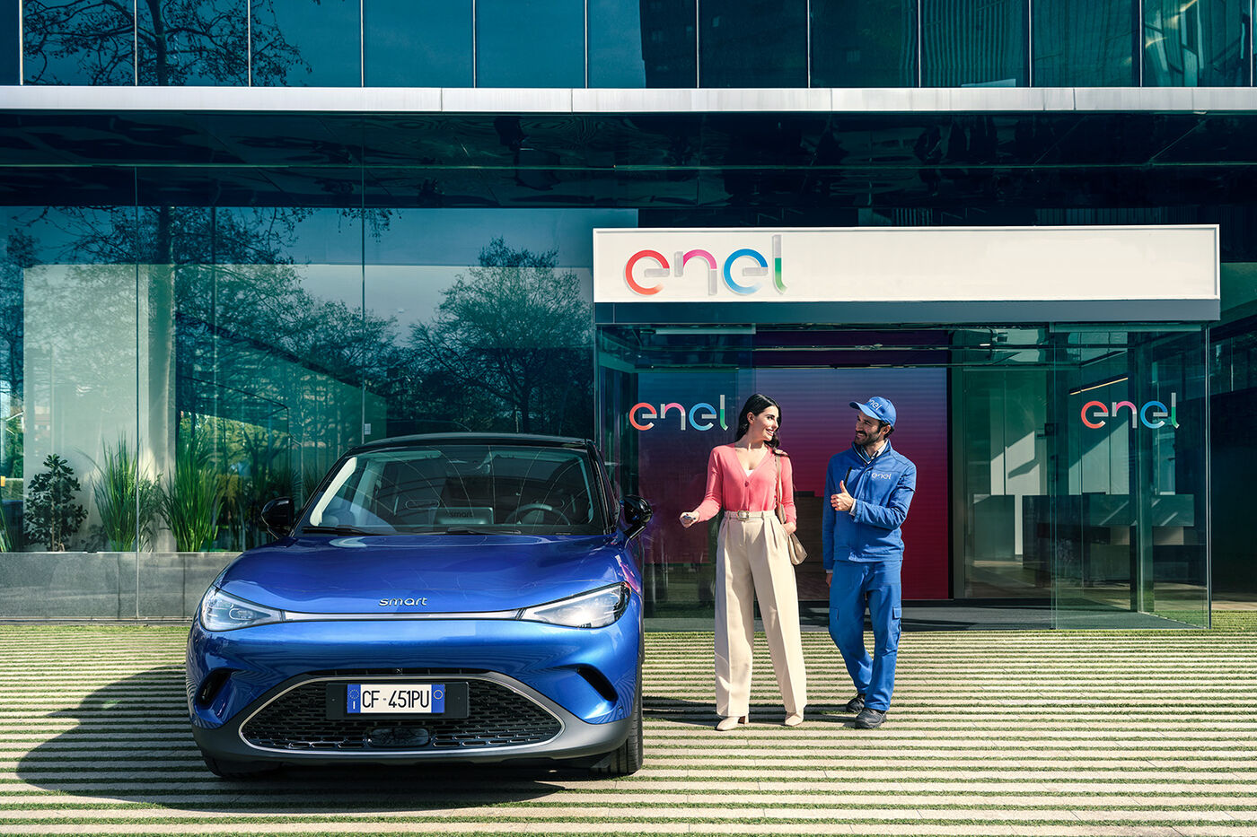 un uomo e una donna vicini a un'auto elettrica in carica 