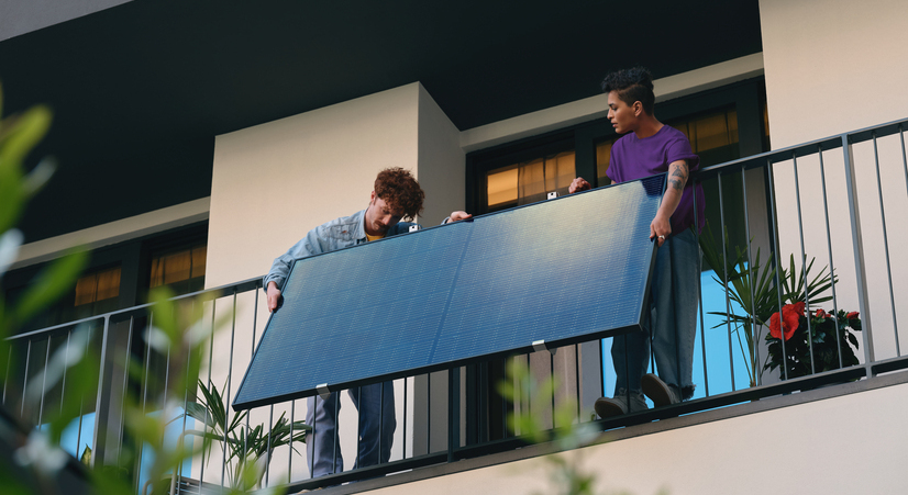 due ragazzi installano un pannello solare in balcone