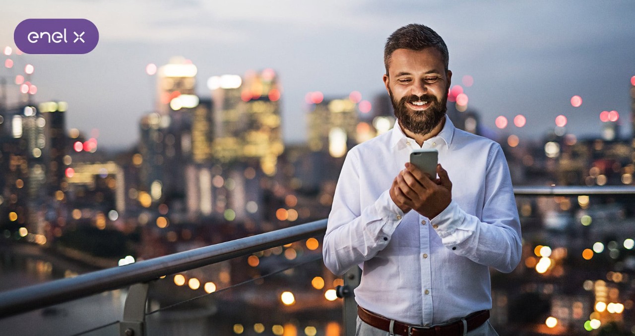 Ragazzo con smartphone sulla terrazza di una città con grattacieli